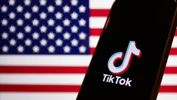 American flag displayed on a laptop screen and TikTok logo displayed on a phone screen are seen in this illustration photo taken in Warsaw, Poland on March 14, 2024.
