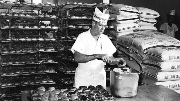 Cooper Do-Nuts owner Richard Evans adds icing at the family shop.