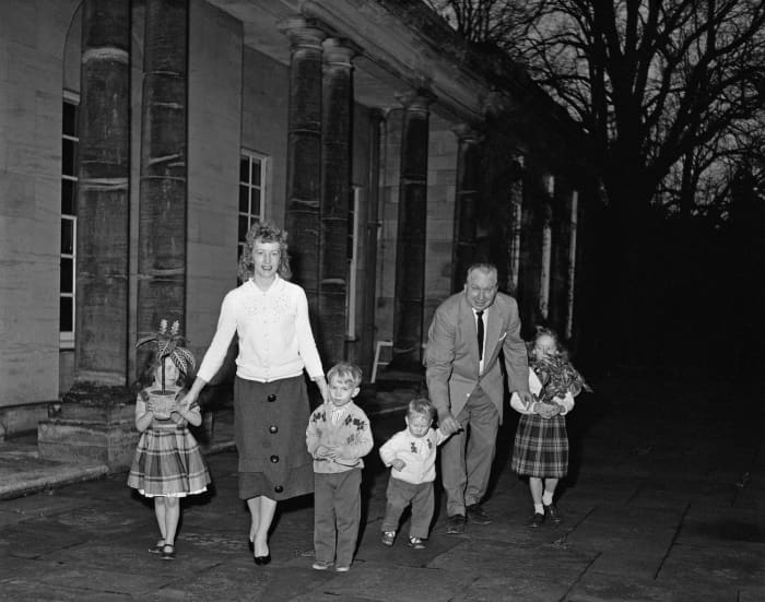 L. Ron Hubbard (1911 - 1986), writer of science fiction and founder of the Church of Scientology, outside his Sussex mansion, Saint Hill Manor, with his family, December 1959. From left to right, Suzette, wife Mary Sue Hubbard, Quentin, Arthur, Hubbard and Diana. The potted plants are being used for Hubbard's experiments into the emotional sensitivity of flora.